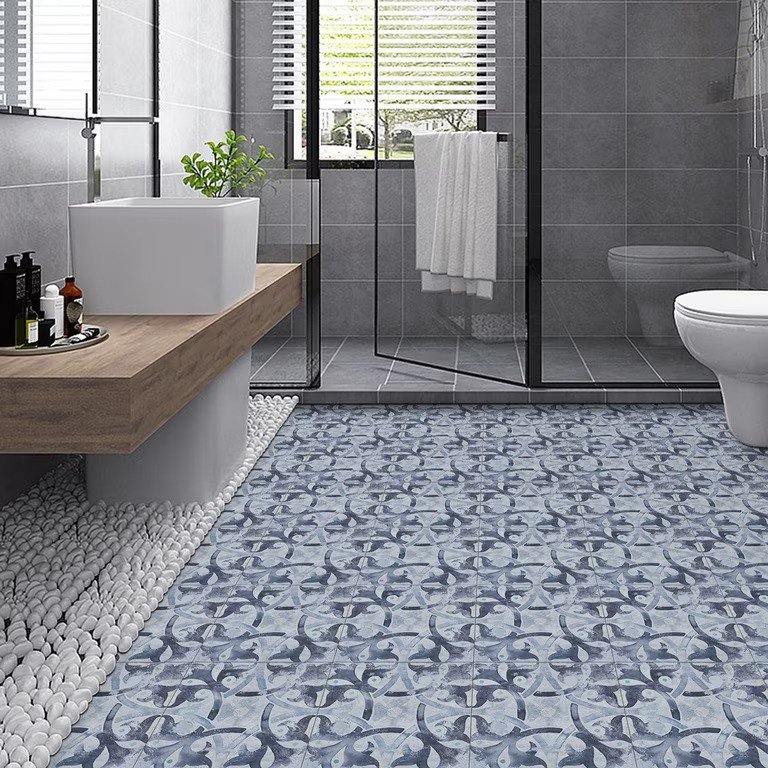 Blue patterned peel and stick floor tiles in a modern bathroom with glass shower