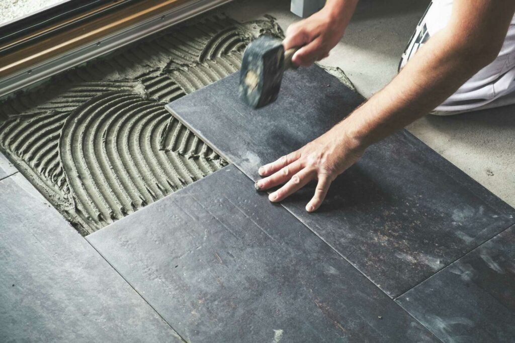 Tools and materials used to prepare an existing floor for new peel-and-stick tiles.